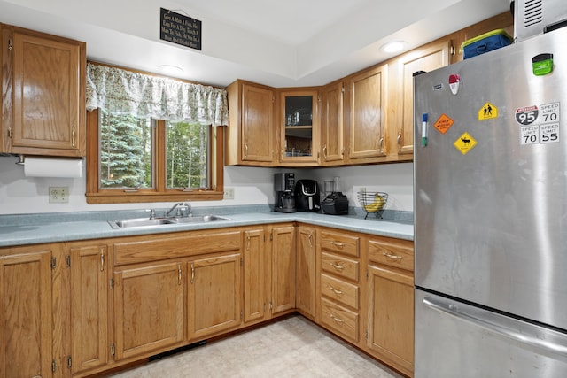 14 Moody Pond Rd, Windsor, ME 04363 - kitchen featuring freestanding refrigerator, light countertops, brown cabinets, glass insert cabinets, and light floors