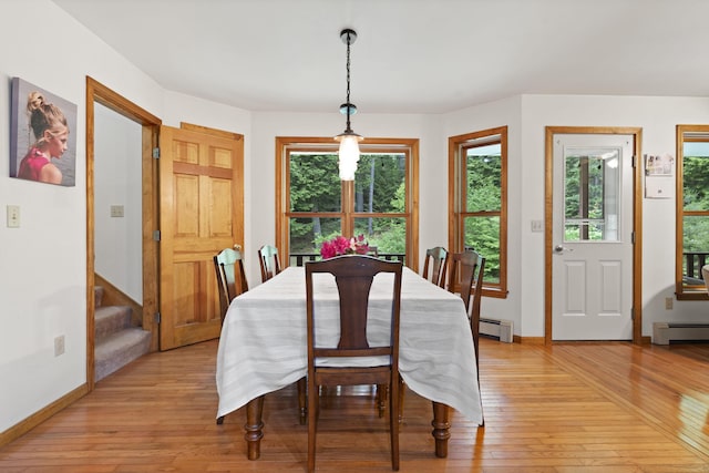 14 Moody Pond Rd, Windsor, ME 04363 - dining room featuring a baseboard heating unit, light wood-style flooring, stairway, and healthy amount of natural light