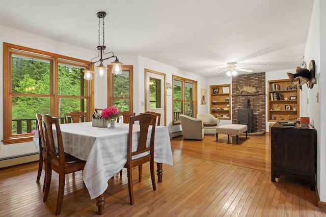 14 Moody Pond Rd, Windsor, ME 04363 - dining area with light wood-style floors, a wood stove, and healthy amount of natural light