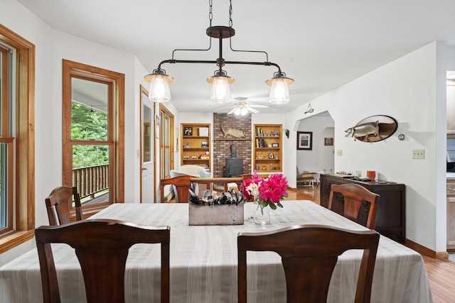 14 Moody Pond Rd, Windsor, ME 04363 - dining area with a wood stove, wood finished floors, a ceiling fan, arched walkways, and built in features