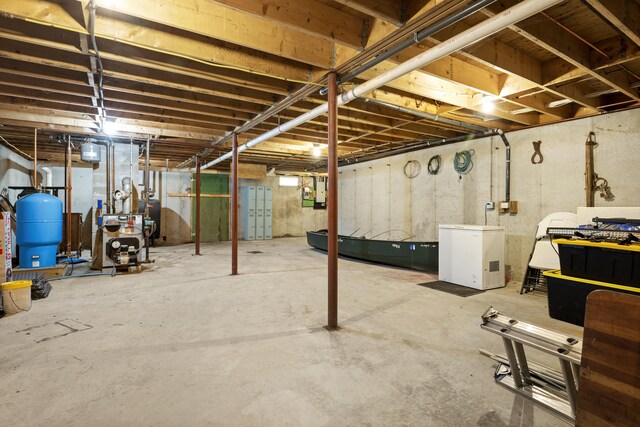 14 Moody Pond Rd, Windsor, ME 04363 - unfinished basement with a water pressure tank, refrigerator, and a heating unit