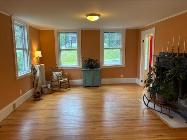 37 Central St, Hallowell, ME 04347 - sitting room featuring light wood-style floors, crown molding, and radiator heating unit