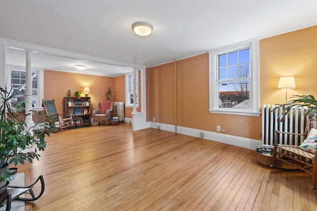 37 Central St, Hallowell, ME 04347 - sitting room featuring light wood-type flooring, decorative columns, and radiator
