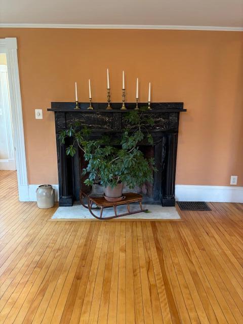37 Central St, Hallowell, ME 04347 - detailed view of a fireplace with flush hearth, wood finished floors, and ornamental molding