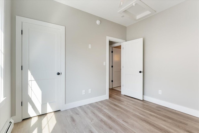 50 Ocean Park Rd Unit 102, Saco, ME 04072 - unfurnished bedroom with baseboard heating, wood finished floors, and attic access