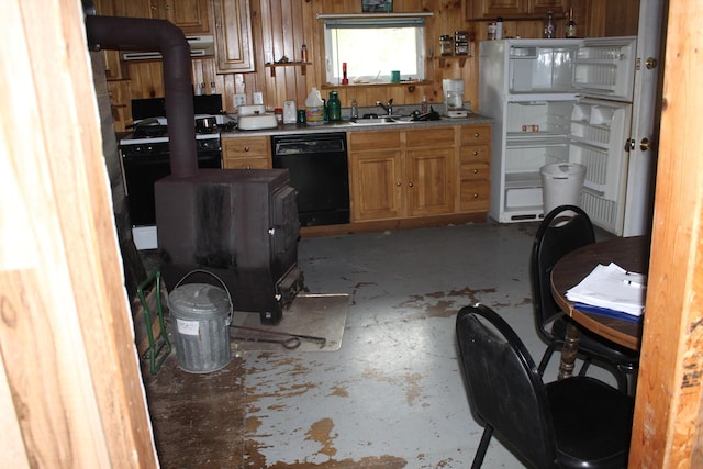 1100 Shin Pond Rd, Mount Chase, ME 04765 - kitchen featuring black appliances, concrete flooring, wooden walls, a wood stove, and brown cabinetry