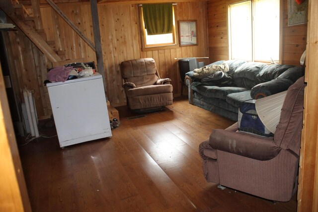 1100 Shin Pond Rd, Mount Chase, ME 04765 - living room featuring hardwood / wood-style floors, wood walls, washer / clothes dryer, radiator, and stairs