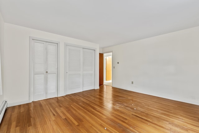28 Colony Rd, Augusta, ME 04330 - unfurnished bedroom featuring multiple closets, light wood-type flooring, and a baseboard heating unit