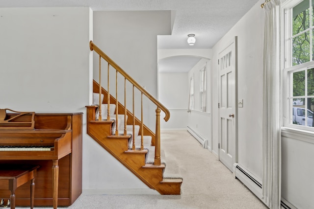 28 Colony Rd, Augusta, ME 04330 - entryway with a baseboard heating unit, arched walkways, carpet flooring, and stairway
