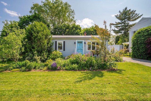 212 Lincoln St, Bangor, ME 04401 - view of front of house with a chimney, a front yard, and a metal roof