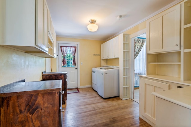 212 Lincoln St, Bangor, ME 04401 - laundry area with cabinet space, washer and clothes dryer, light wood-style flooring, and crown molding