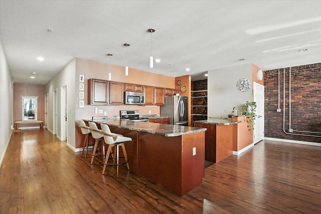 43 Lisbon St Unit 2B, Lewiston, ME 04240 - kitchen featuring stainless steel appliances, a peninsula, brown cabinetry, dark wood-style flooring, and recessed lighting