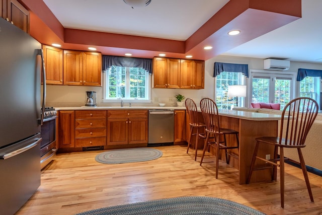 51 Tracy Cove Cir, Rome, ME 04963 - kitchen with appliances with stainless steel finishes, a wall mounted air conditioner, brown cabinets, light wood finished floors, and recessed lighting