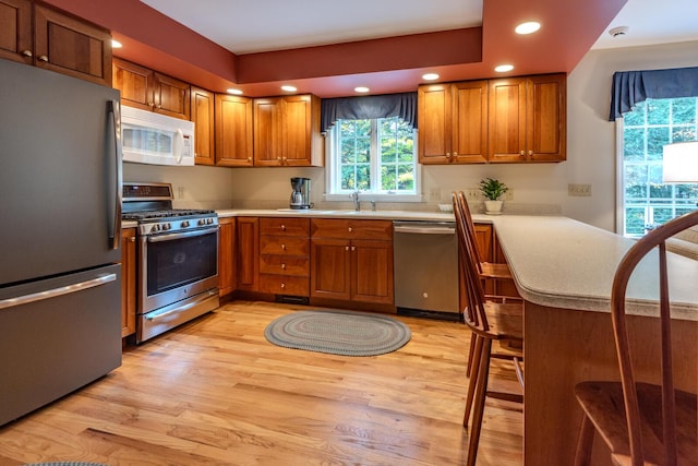 51 Tracy Cove Cir, Rome, ME 04963 - kitchen featuring appliances with stainless steel finishes, brown cabinets, light wood-style flooring, light countertops, and recessed lighting