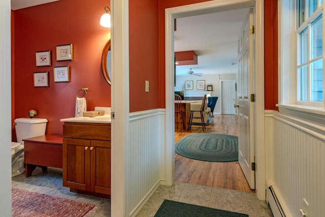 51 Tracy Cove Cir, Rome, ME 04963 - bathroom with a baseboard heating unit, wainscoting, vanity, a ceiling fan, and tile patterned floors