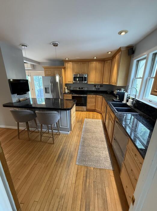 45 Tyler Ave, Bangor, ME 04401 - kitchen featuring stainless steel appliances, healthy amount of natural light, a kitchen breakfast bar, light wood finished floors, and recessed lighting
