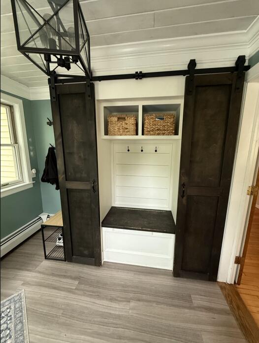 45 Tyler Ave, Bangor, ME 04401 - mudroom featuring a barn door, wood finished floors, a baseboard radiator, and ornamental molding