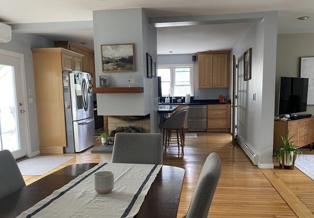 45 Tyler Ave, Bangor, ME 04401 - dining room with baseboard heating, light wood-style flooring, and a wall mounted air conditioner
