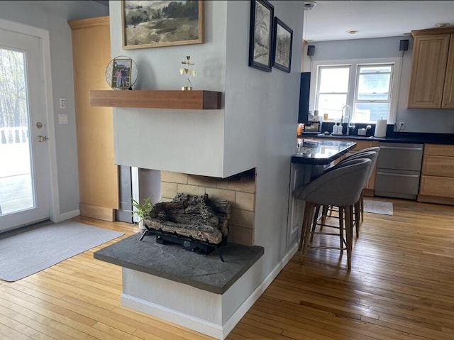45 Tyler Ave, Bangor, ME 04401 - kitchen with dishwasher, wood-type flooring, dark countertops, and a kitchen breakfast bar