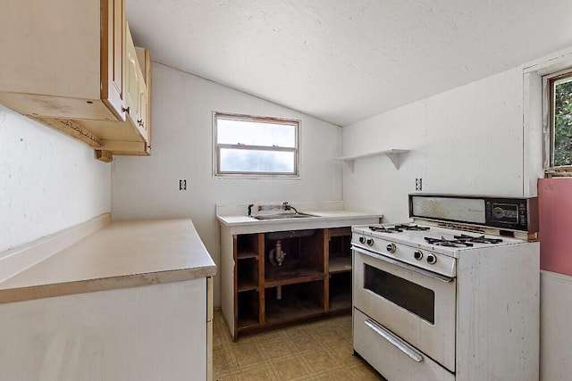 259 Drury Rd, Solon, ME 04979 - kitchen with white range with gas cooktop, open shelves, light floors, vaulted ceiling, and light countertops