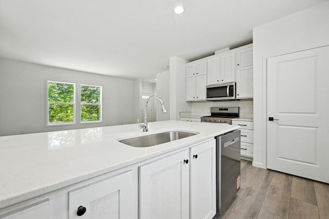 4 Willis Rd, Benton, ME 04901 - kitchen with appliances with stainless steel finishes, light countertops, white cabinets, light wood finished floors, and backsplash