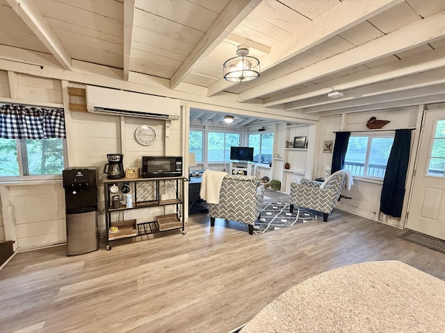 628 Springy Pond Rd, Otis, ME 04605 - living area featuring a wall unit AC, wood finished floors, and a wood ceiling with exposed beams