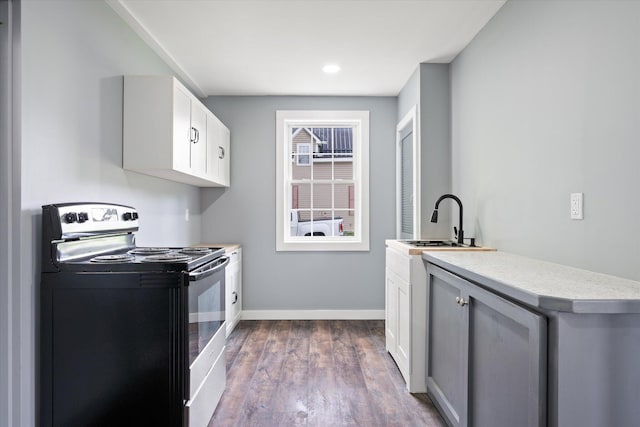 159 N St, Calais, ME 04619 - kitchen with range with electric cooktop, dark wood-type flooring, light countertops, white cabinetry, and recessed lighting