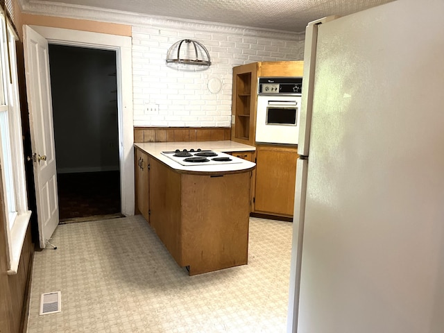 6 Autumn St, Lisbon, ME 04252 - kitchen with white appliances, a peninsula, light flooring, brown cabinets, and ornamental molding