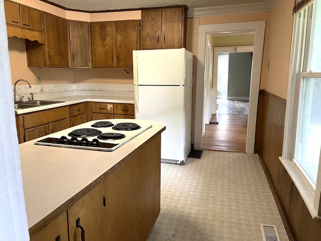 6 Autumn St, Lisbon, ME 04252 - kitchen with white appliances, light countertops, a wainscoted wall, crown molding, and brown cabinetry