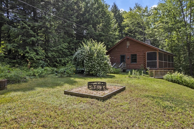 31 Convene Rd, Sebago, ME 04029 - view of green lawn with an outdoor fire pit, a sunroom, and a view of trees