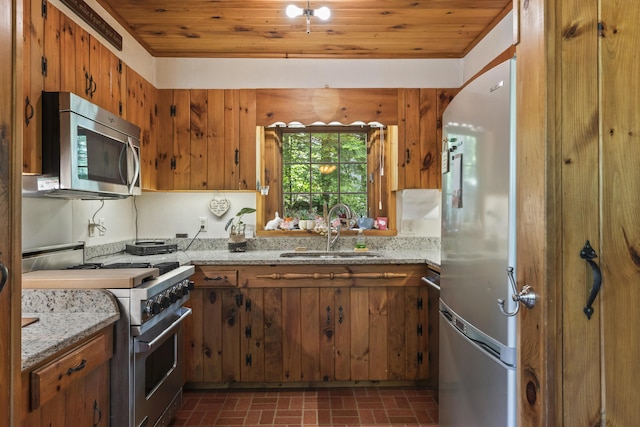 31 Convene Rd, Sebago, ME 04029 - kitchen featuring appliances with stainless steel finishes, brick patterned flooring, wood ceiling, brown cabinets, and light stone countertops