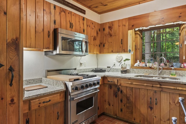 31 Convene Rd, Sebago, ME 04029 - kitchen featuring stainless steel appliances, brick patterned floors, brown cabinets, light stone countertops, and wood ceiling