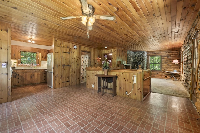 31 Convene Rd, Sebago, ME 04029 - kitchen featuring refrigerator, brick flooring, a ceiling fan, wood ceiling, and wooden walls