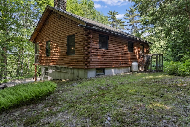31 Convene Rd, Sebago, ME 04029 - view of side of home with a chimney, log siding, and a lawn