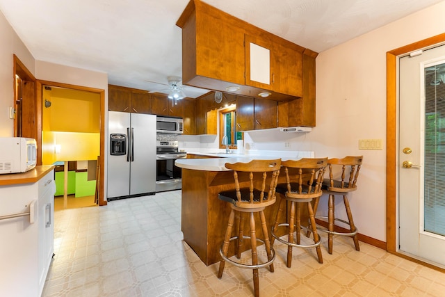 106 Bowdoinham Rd, Sabattus, ME 04280 - kitchen featuring appliances with stainless steel finishes, light floors, a peninsula, ceiling fan, and light countertops