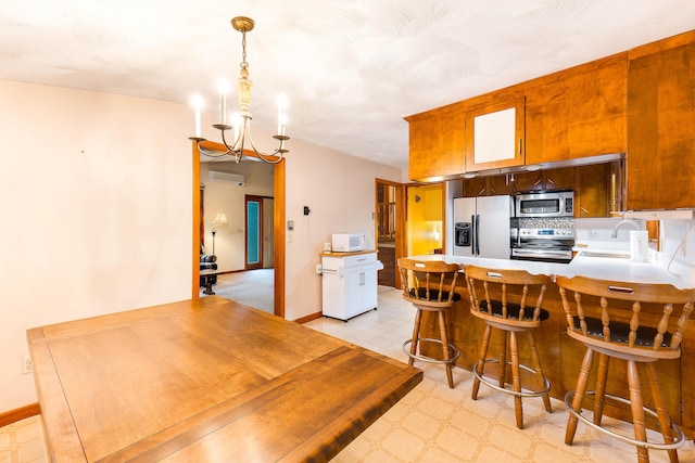 106 Bowdoinham Rd, Sabattus, ME 04280 - kitchen featuring appliances with stainless steel finishes, a wall mounted air conditioner, a chandelier, light countertops, and light floors