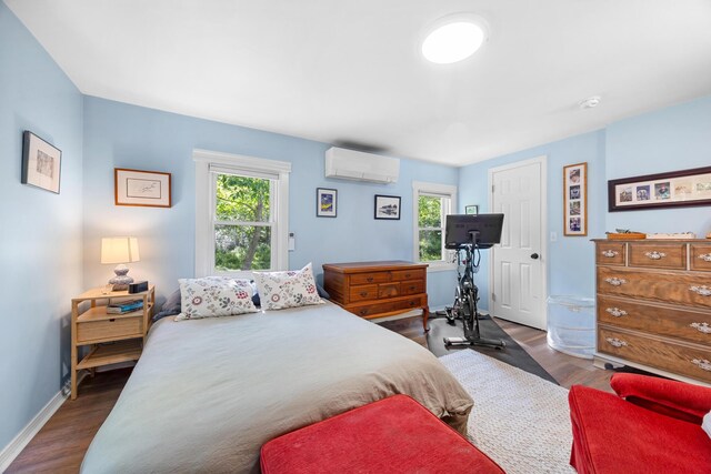 1165 Castine Rd, Penobscot, ME 04476 - bedroom featuring an AC wall unit, multiple windows, and dark wood-style floors