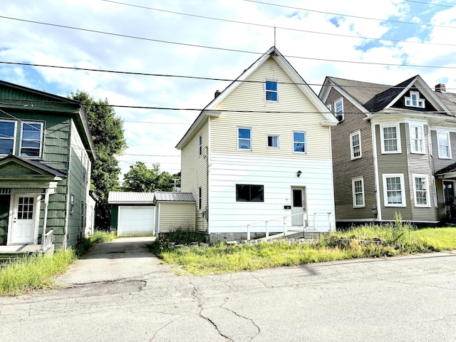 84 Pine St, Millinocket, ME 04462 - view of front facade featuring an outbuilding, asphalt driveway, and a detached garage