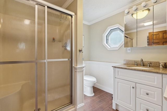 115 34th St, Acton, ME 04001 - bathroom featuring wood finished floors, crown molding, vanity, a shower stall, and a wainscoted wall