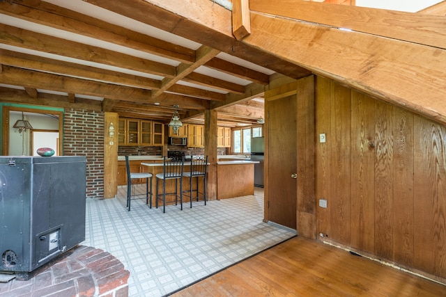 115 Swain Farm Rd, Rumford, ME 04276 - kitchen featuring appliances with stainless steel finishes, beamed ceiling, a kitchen breakfast bar, wood finished floors, and wood walls