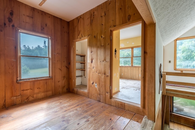 115 Swain Farm Rd, Rumford, ME 04276 - spare room featuring wood-type flooring, wooden walls, and healthy amount of natural light