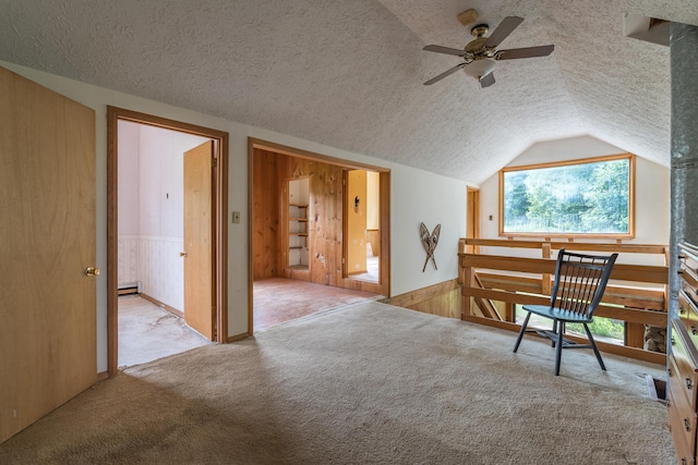 115 Swain Farm Rd, Rumford, ME 04276 - living area featuring a textured ceiling, vaulted ceiling, a ceiling fan, carpet, and wainscoting