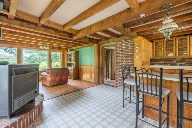 115 Swain Farm Rd, Rumford, ME 04276 - kitchen with a wainscoted wall, wooden walls, beamed ceiling, glass insert cabinets, and light countertops