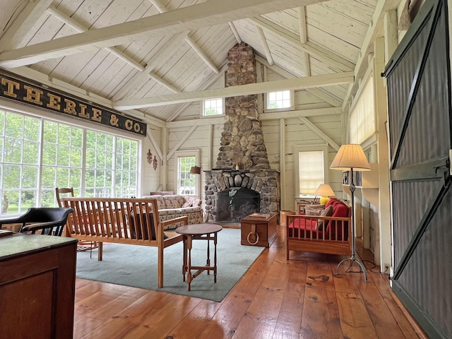 95 Main St, Castine, ME 04421 - living room with hardwood / wood-style flooring, a wood ceiling with exposed beams, healthy amount of natural light, high vaulted ceiling, and a stone fireplace