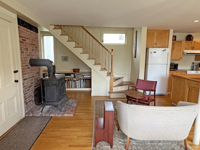 95 Main St, Castine, ME 04421 - living area featuring a wood stove, light wood-style floors, and stairway
