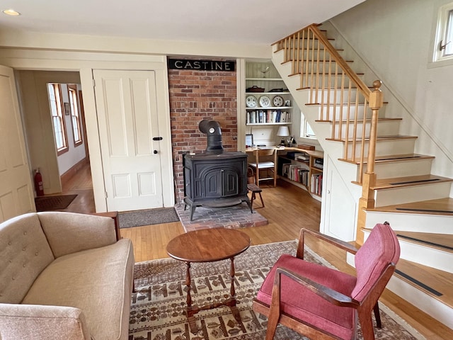95 Main St, Castine, ME 04421 - living area with wood finished floors, stairway, a wood stove, plenty of natural light, and recessed lighting