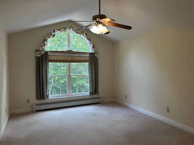 1 S Ridge Dr, Winslow, ME 04901 - empty room with a baseboard radiator, healthy amount of natural light, lofted ceiling, ceiling fan, and carpet floors
