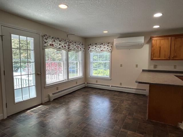 1 S Ridge Dr, Winslow, ME 04901 - unfurnished dining area featuring a wall unit AC, plenty of natural light, recessed lighting, a textured ceiling, and baseboard heating