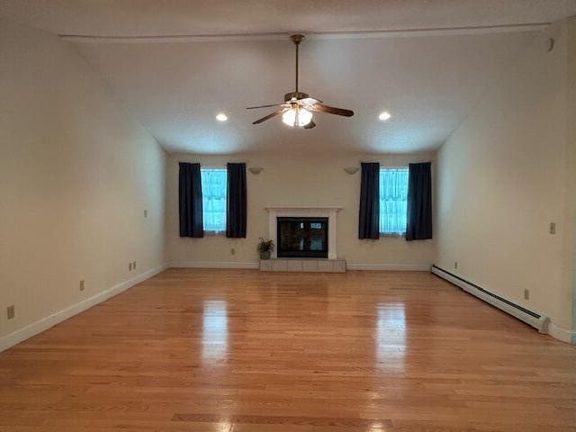 1 S Ridge Dr, Winslow, ME 04901 - unfurnished living room with baseboard heating, ceiling fan, light wood finished floors, plenty of natural light, and vaulted ceiling