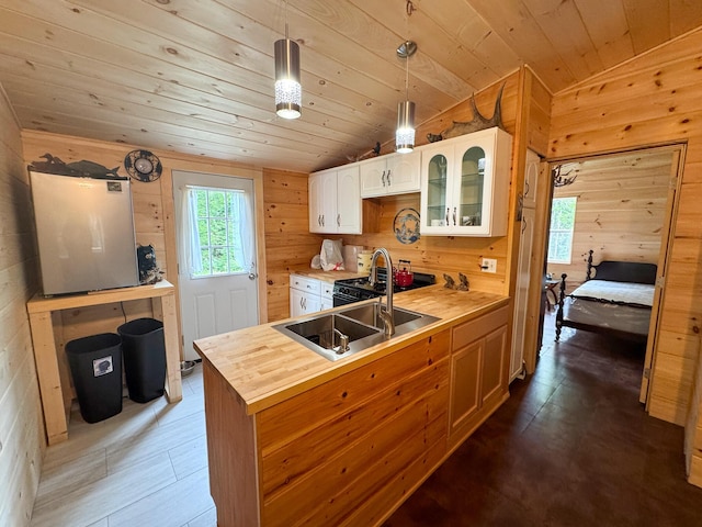 147 Loop Rd, Lincoln, ME 04457 - kitchen featuring butcher block counters, wood walls, wood ceiling, white cabinets, and glass insert cabinets